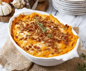 Delicious cheesy sweet potato casserole topped with melted cheese and crispy golden-brown crust, served as a savory side dish for holidays and gatherings.