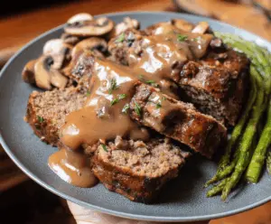 Delicious homemade meatloaf topped with rich mushroom gravy served on a plate, perfect for a comforting family dinner.