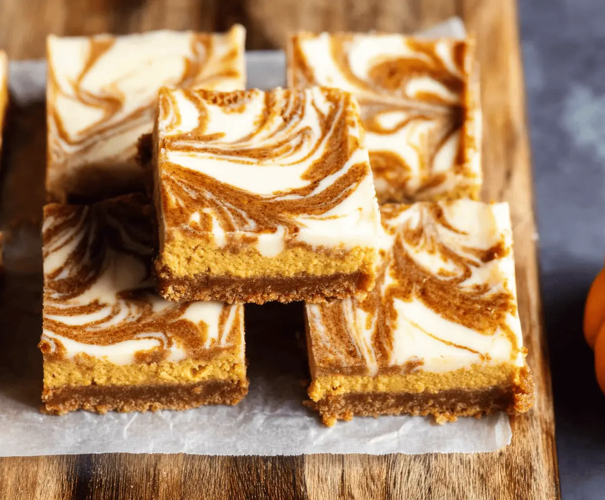 Delicious Pumpkin Swirl Cheesecake Bars with a creamy swirl and crumbly crust, perfect for fall desserts.