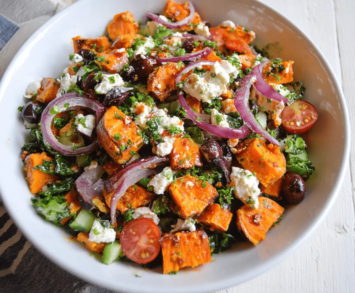 Colorful sweet potato Greek salad with feta cheese, cherry tomatoes, cucumbers, red onions, and fresh herbs in a bowl, healthy and vibrant dish