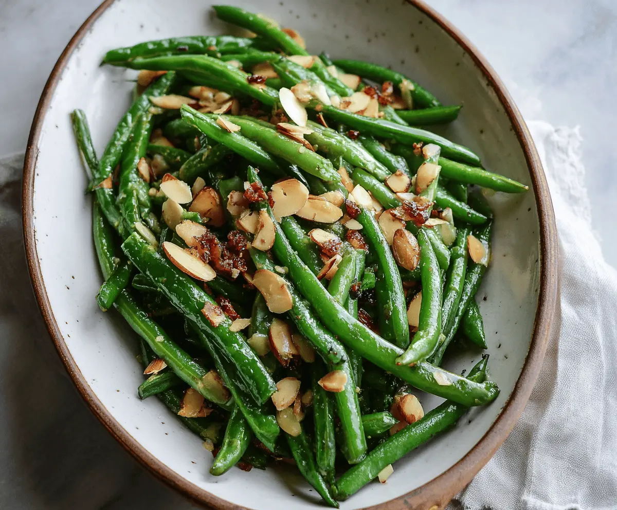 Fresh green bean almondine dish with toasted almonds and lemon zest on a rustic plate.
