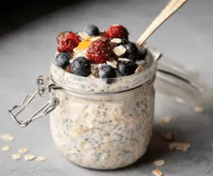 Creamy oat milk overnight oats in a glass jar with fresh fruit topping for a healthy breakfast.