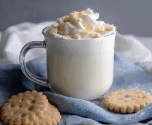 A cozy cup of Sugar Cookie White Hot Chocolate topped with whipped cream and sprinkles, perfect for winter indulgence.