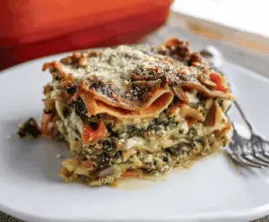 Delicious sweet potato spinach lasagna layered with melted cheese and fresh greens.