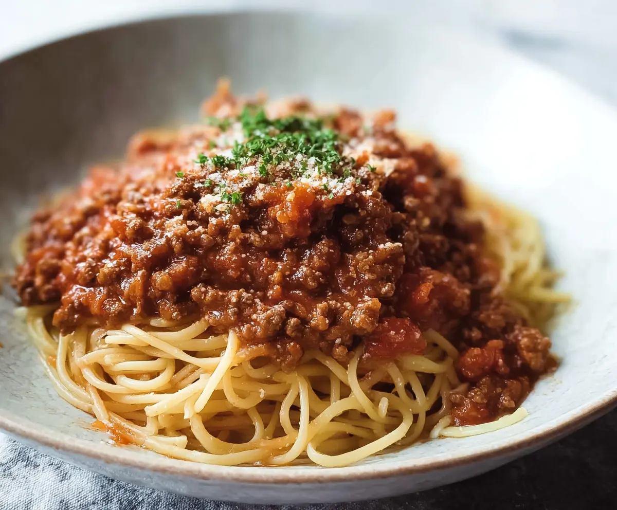 Delicious bowl of homemade Bolognese pasta with rich tomato sauce and melted cheese