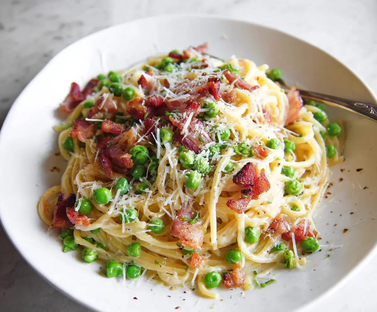 Delicious bacon and pea pasta dish with fresh ingredients and creamy sauce.