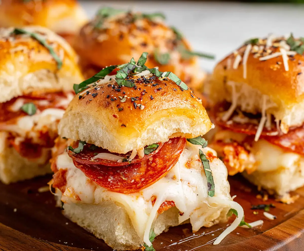 Delicious pepperoni pizza sliders topped with melted cheese on a baking tray.