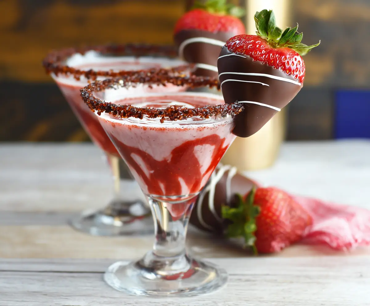 Elegant chocolate covered strawberry martini with fresh strawberries and chocolate drizzle