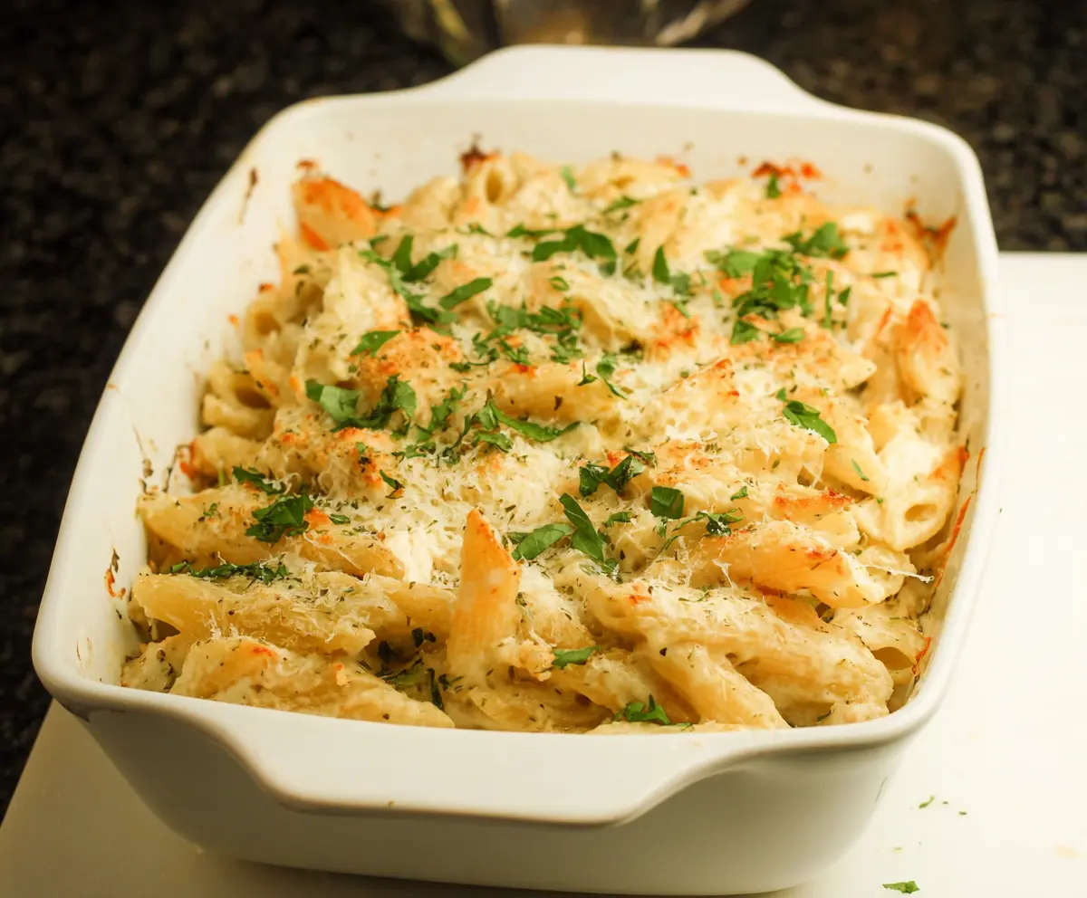 Creamy Cottage Cheese Alfredo Pasta Bake in a baking dish with golden cheese topping.