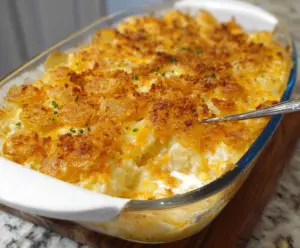 Delicious cheesy potato casserole in a baking dish, topped with melted cheese and herbs.