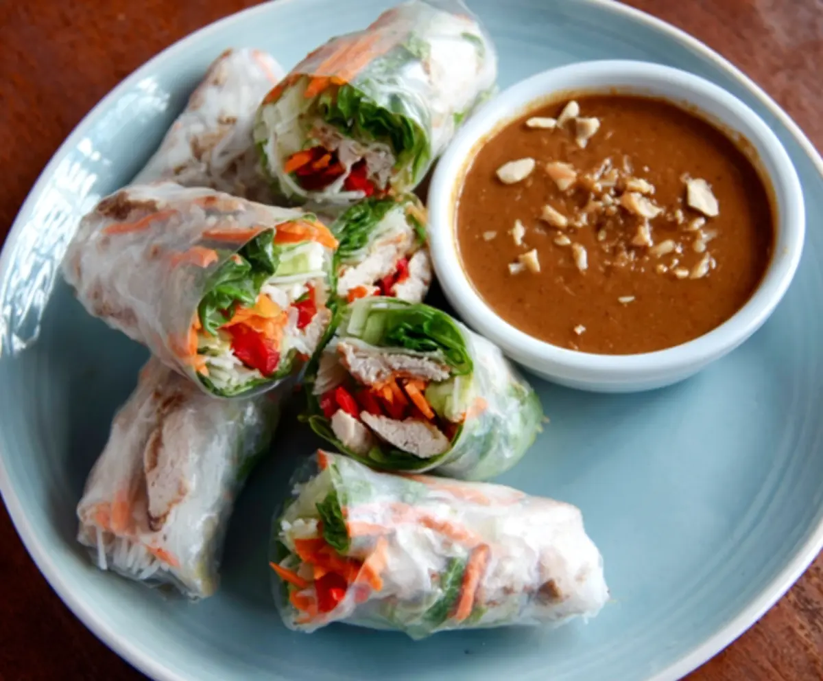 Delicious pork spring rolls served with a peanut lime dipping sauce, perfect for appetizers or light meals.