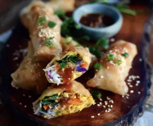 Delicious turmeric sesame chicken spring rolls filled with vibrant vegetables and herbs