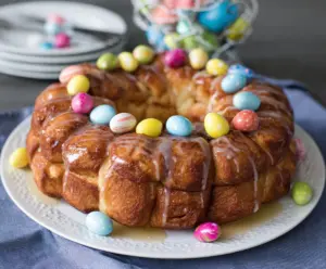 Delicious Easter Brunch Monkey Bread topped with powdered sugar and fresh berries on a festive table.