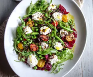 Fresh spring salad with goat cheese, colorful vegetables, and herbs on a rustic plate.